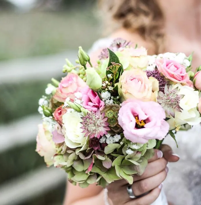 First Blush bouquet of pink roses and lisianthus held in both hands